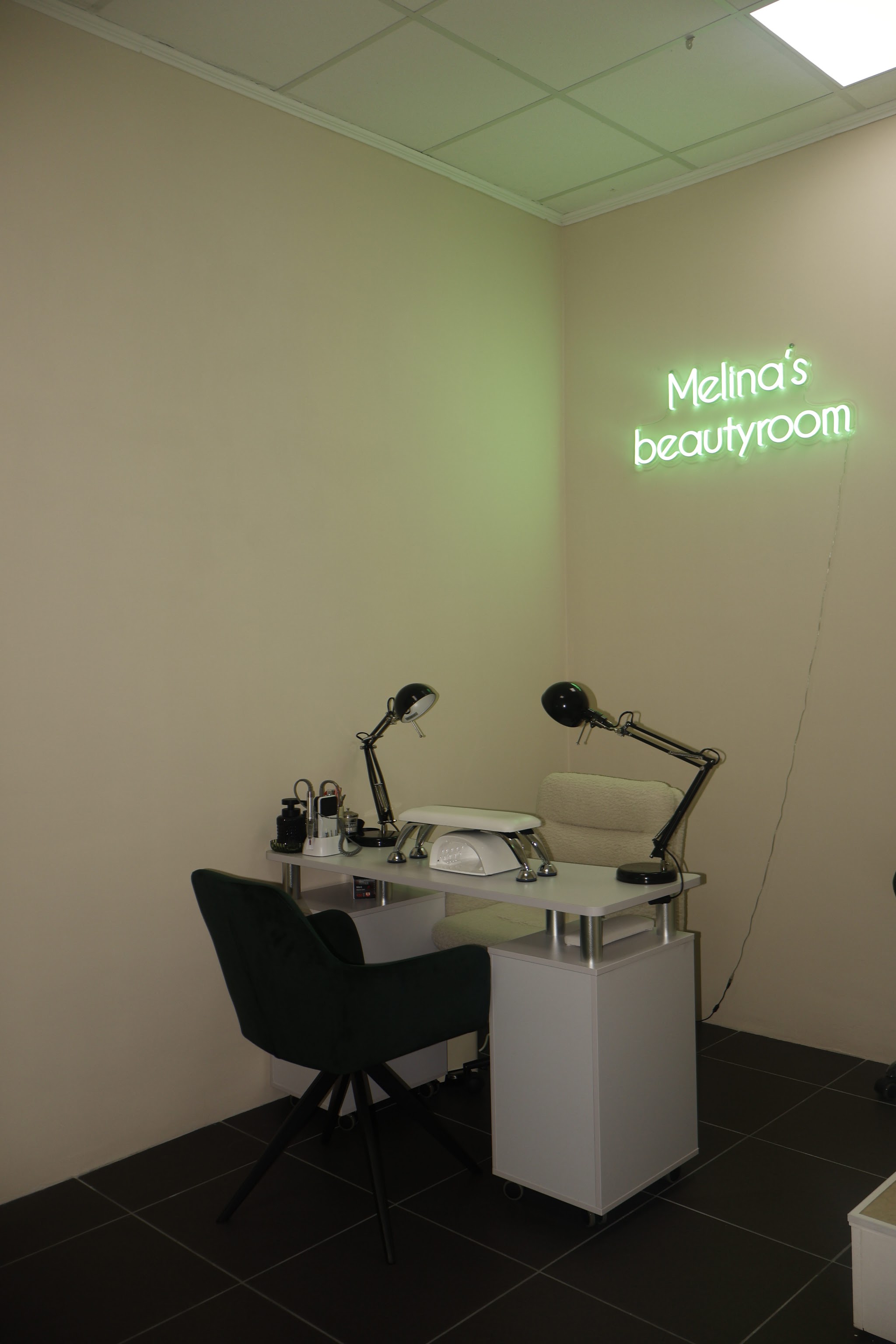 Nageltafel met groene stoel onder het neonlogo Melina’s beautyroom